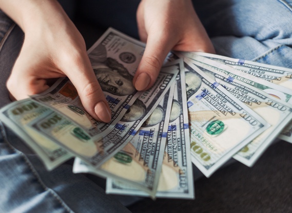 Hands counting a fan of hundred dollar bills