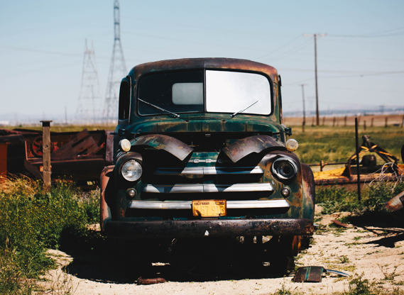 Rusted vintage pickup truck sitting abandoned in a field